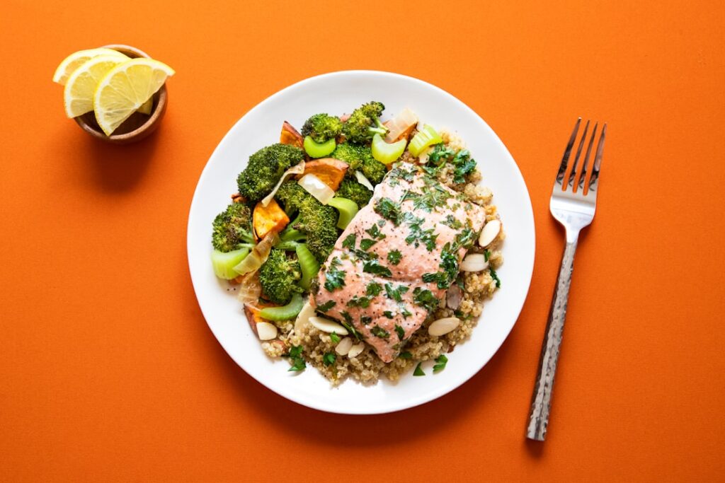 Grilled salmon with quinoa and broccoli on a white plate — a lean protein meal suitable for an IBS-friendly diet