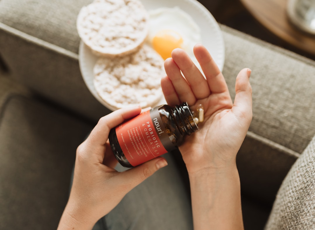 Woman holding probiotic supplement capsules in her hand for daily gut health routine