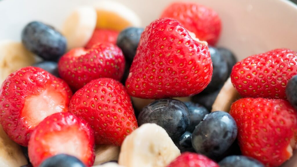 Bowl of fresh strawberries, blueberries, and banana slices — gut-friendly fruits for people managing IBS symptoms