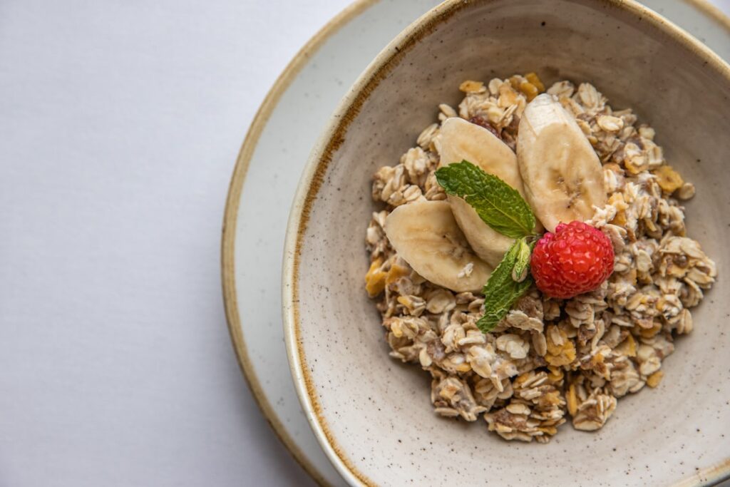 Bowl of oatmeal topped with banana slices and a strawberry — a soluble fiber food that may support IBS digestive comfort