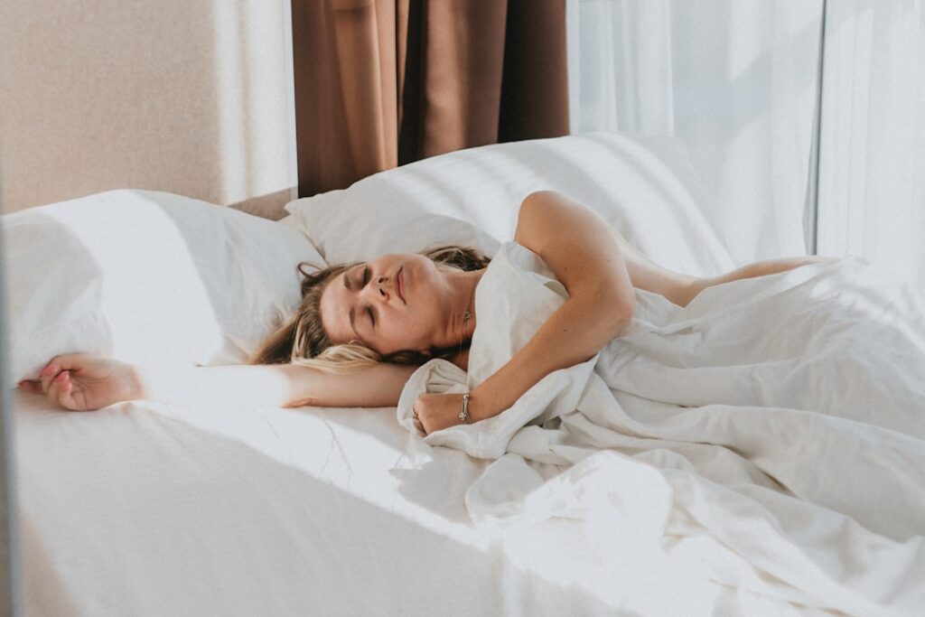 Woman resting peacefully in bed representing the connection between quality sleep and gut health